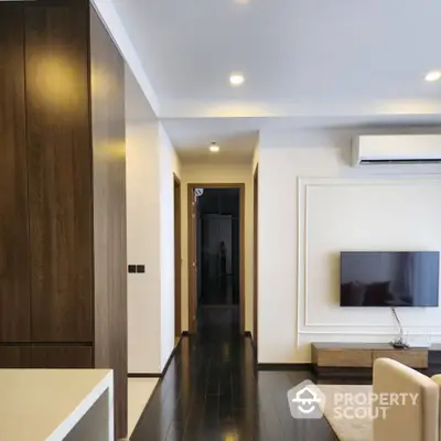 Modern living room with sleek design, wall-mounted TV, and elegant lighting.