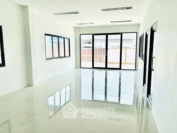 Spacious modern living room with large windows and glossy floors