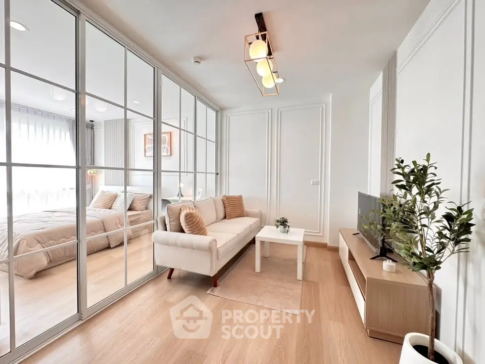 Modern living room with elegant decor and mirrored wall, featuring cozy sofa and stylish lighting.