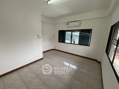 Spacious empty room with tiled flooring and air conditioning, ideal for customization.