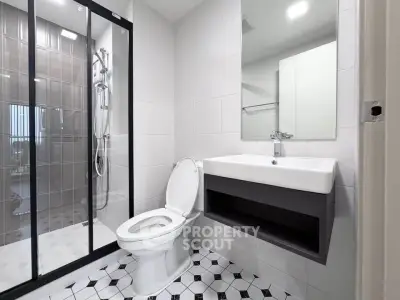 Modern bathroom with sleek shower and stylish sink in contemporary apartment.