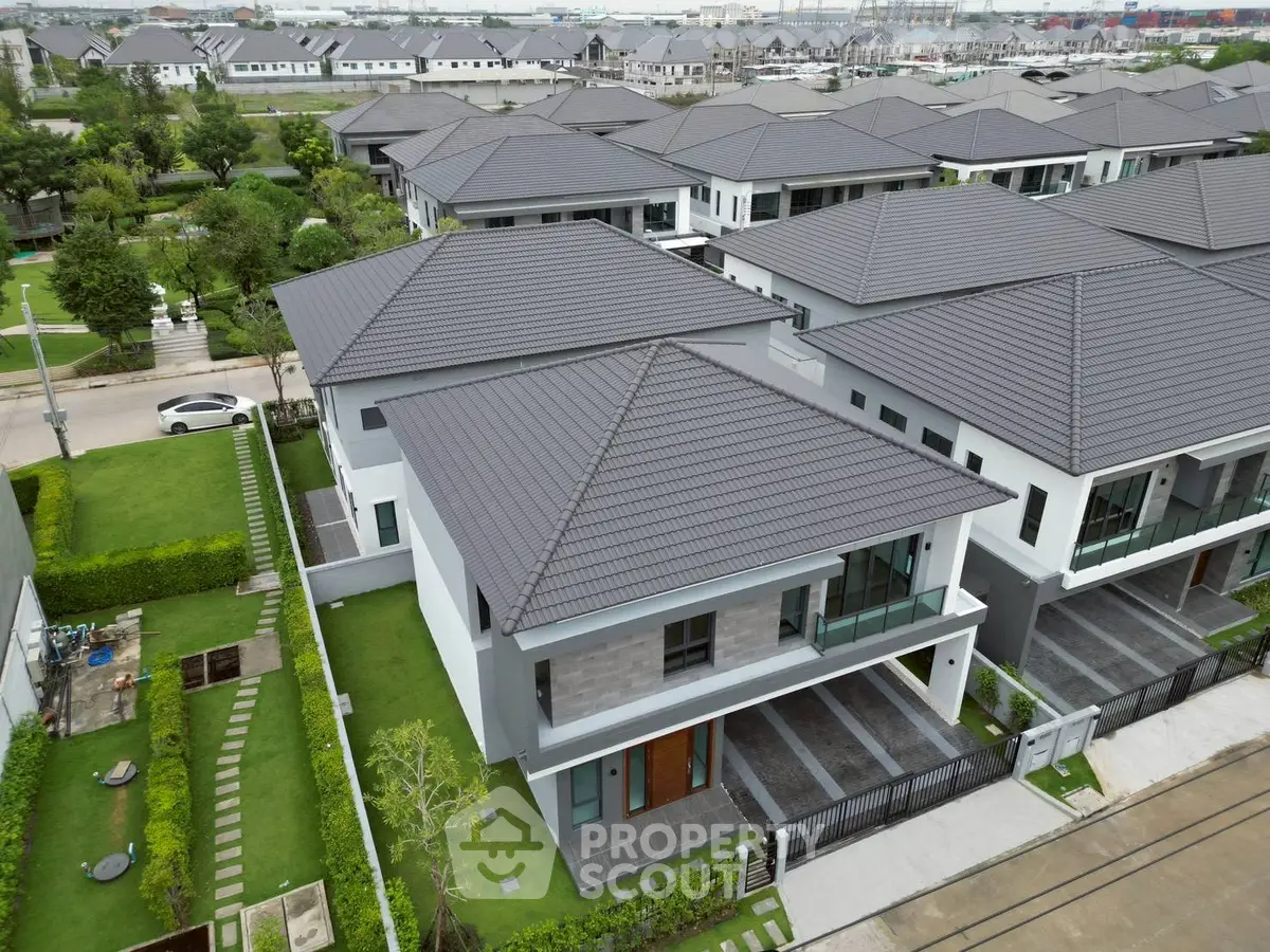 Modern suburban homes with sleek design and lush green lawns in a serene neighborhood.