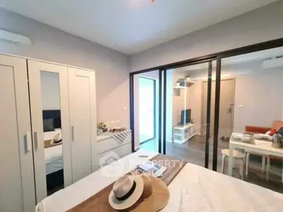 Modern bedroom with sliding glass doors leading to a cozy living area, featuring stylish decor and ample natural light.