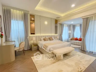 Luxurious bedroom with elegant decor and spacious seating area, featuring soft lighting and modern furnishings.