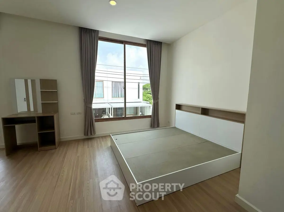 Spacious bedroom with large window and modern minimalist design