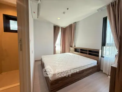Spacious bedroom with large windows and modern design in a stylish apartment.