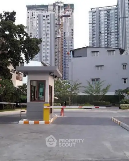 Modern urban building entrance with security booth and high-rise background