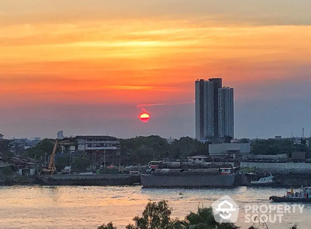 Stunning sunset view over river with city skyline and high-rise buildings