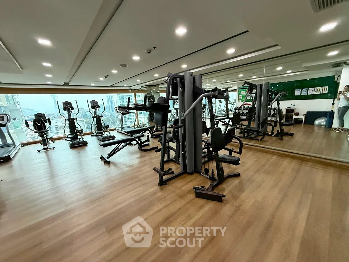 Spacious modern gym with city view and state-of-the-art equipment.