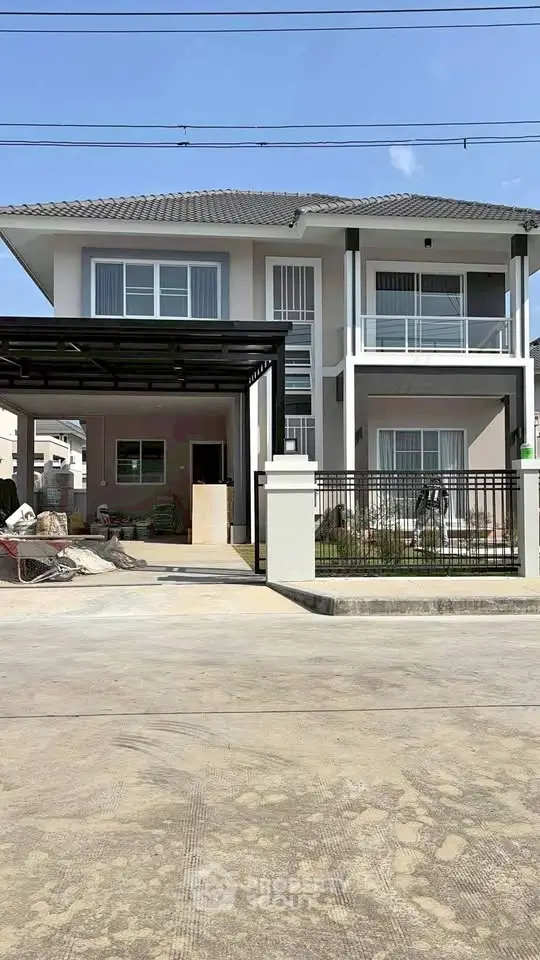 Modern two-story house with spacious driveway and gated entrance.