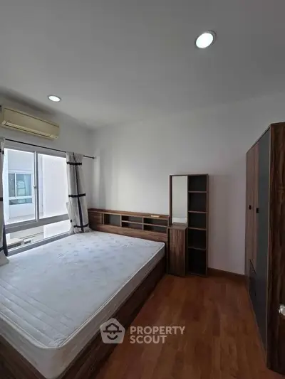Spacious bedroom with modern furnishings and natural light in a stylish apartment.