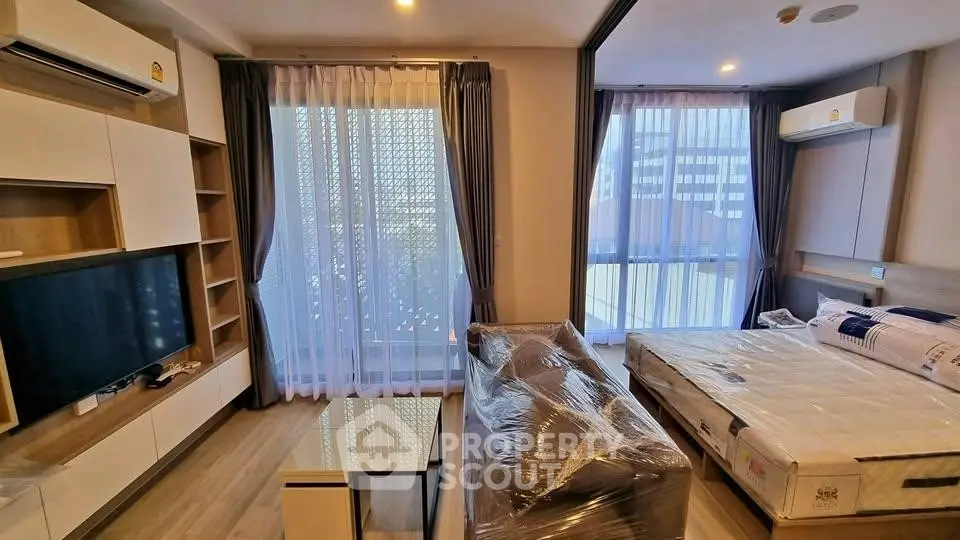 Modern studio apartment with stylish furnishings and large windows for natural light.