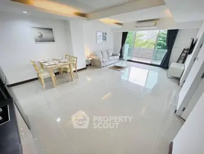 Spacious modern living room with large windows and elegant dining area in a stylish apartment.