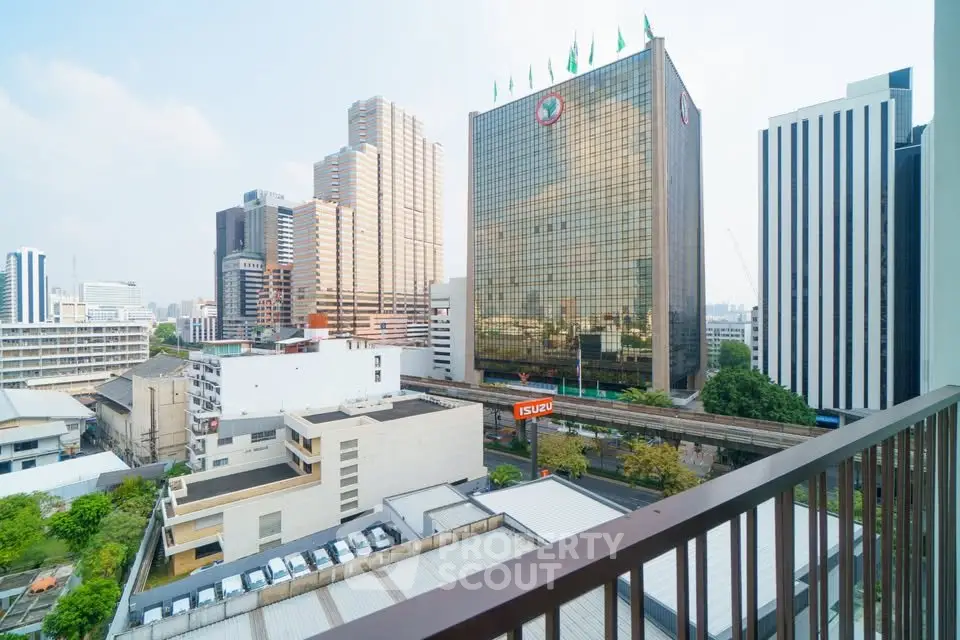 Stunning cityscape view from a high-rise balcony overlooking modern skyscrapers and urban landscape.