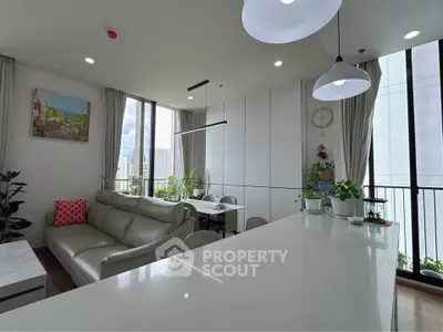 Modern living room with large windows, sleek furniture, and abundant natural light in a high-rise apartment.