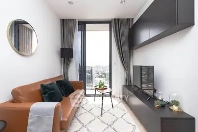 Modern living room with leather sofa, stylish decor, and city view balcony.