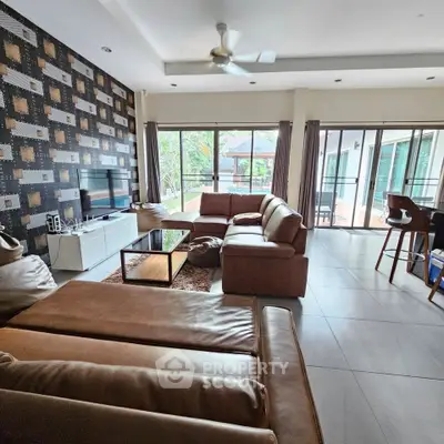 Spacious living room with modern decor and large windows offering natural light.