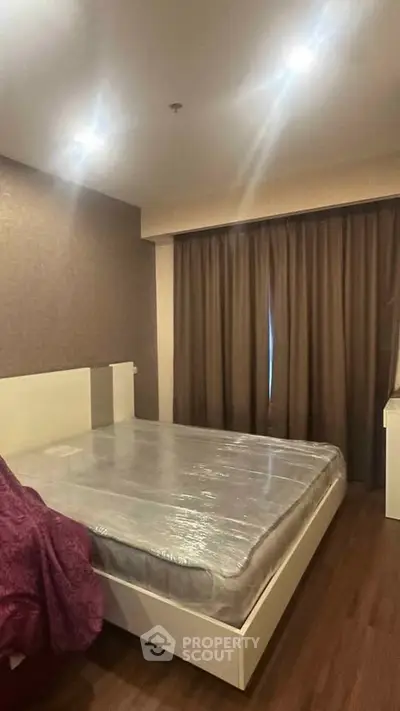 Cozy bedroom with modern decor and natural lighting, featuring a comfortable bed and elegant curtains.
