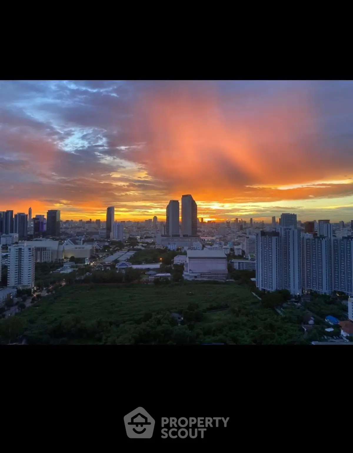 Stunning cityscape view at sunset with vibrant sky over urban skyline, perfect for high-rise living.