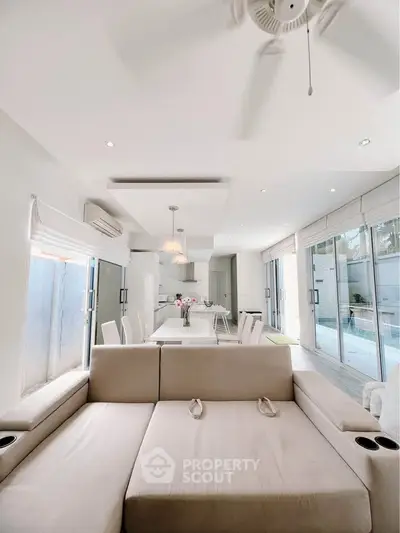 Spacious modern living room with open kitchen and pool view