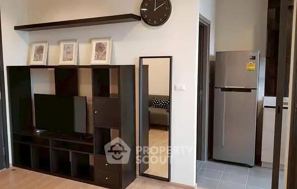 Modern living room with sleek TV unit and stainless steel fridge