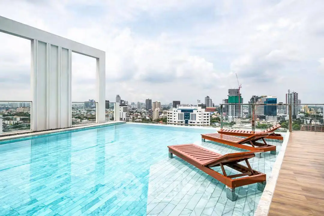 Stunning rooftop pool with panoramic city views and modern lounge chairs.