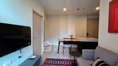 Modern living room with stylish decor and wall-mounted TV in a cozy apartment.
