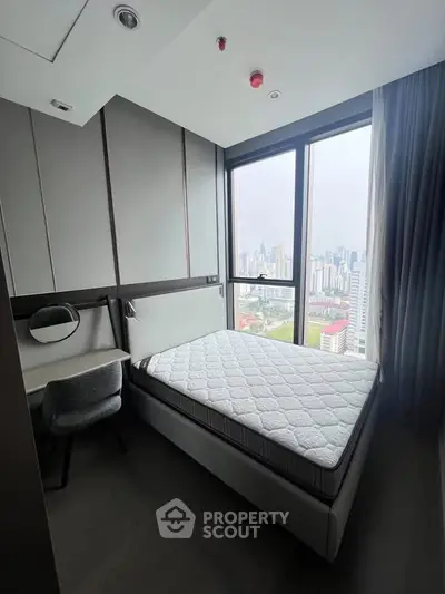 Modern bedroom with city view, featuring a comfortable bed and sleek design in a high-rise apartment.