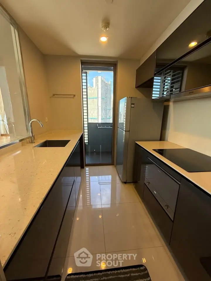 Modern kitchen with sleek cabinetry and balcony view in urban apartment