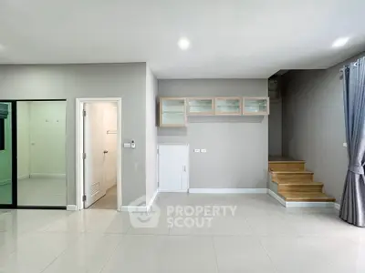 Modern interior with sleek staircase and glass cabinets in open living space