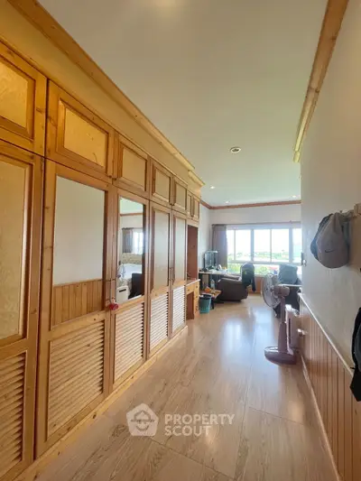Spacious living area with wooden accents and large windows offering natural light and scenic views.