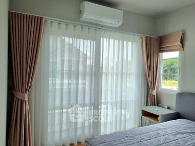 Bright bedroom with large window and modern air conditioning unit