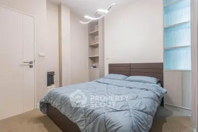 Modern bedroom with stylish lighting and cozy bedding in a contemporary apartment.