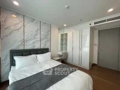 Modern bedroom with stylish decor and ample storage in a luxury apartment.