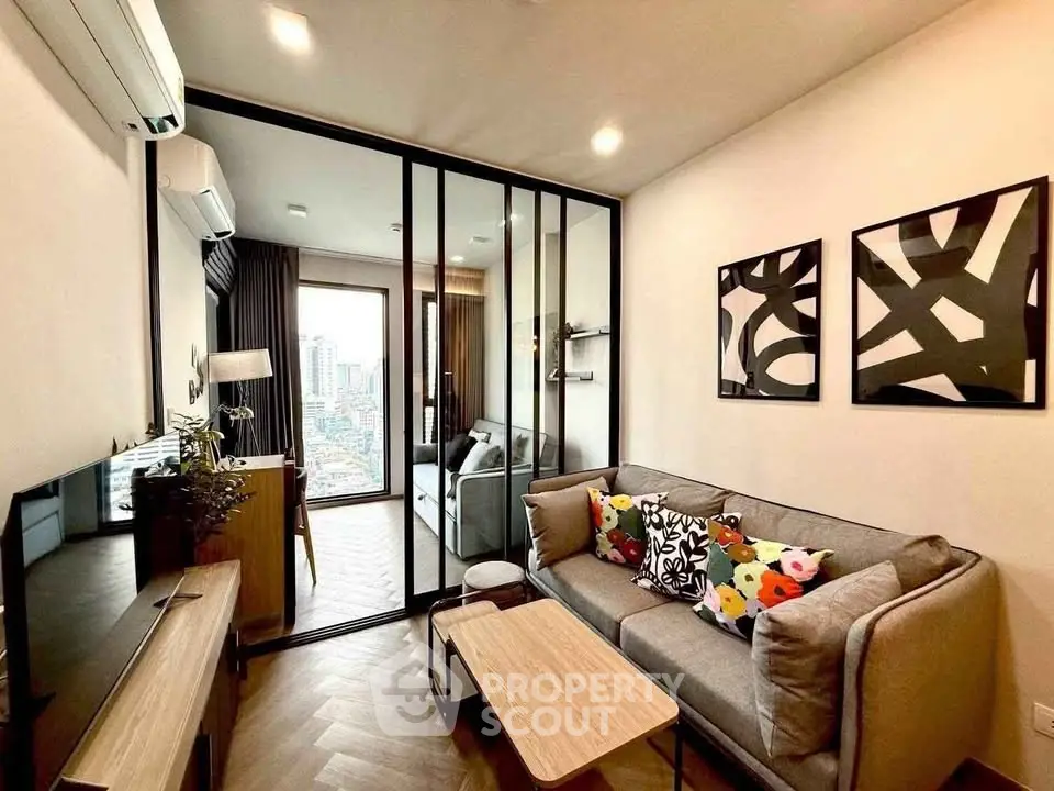 Modern living room with stylish decor and city view, featuring a cozy sofa and abstract art.