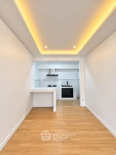 Modern kitchen with open layout and stylish lighting, featuring a gas stove and sleek countertops.