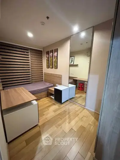 Modern bedroom with wooden flooring and stylish decor in a cozy apartment.