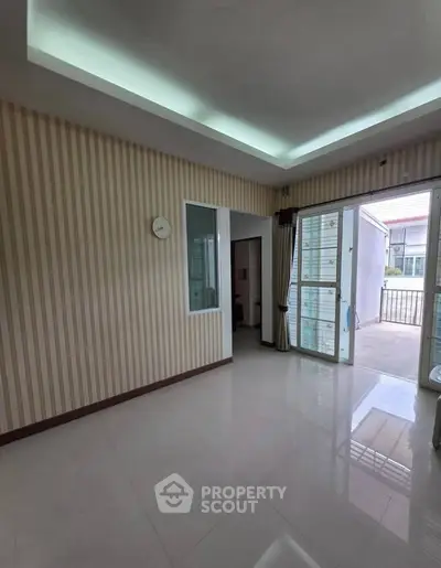 Spacious room with modern design and large windows leading to a balcony, perfect for natural light.