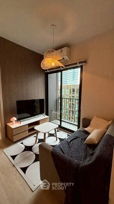 Modern living room with stylish decor and city view balcony in a high-rise apartment.