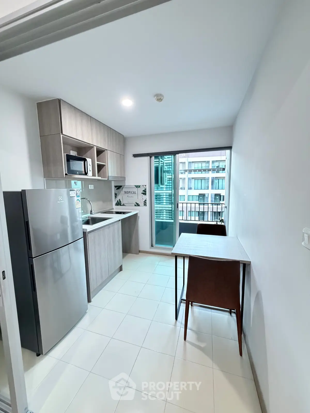 Modern kitchen with sleek appliances and balcony view in urban apartment