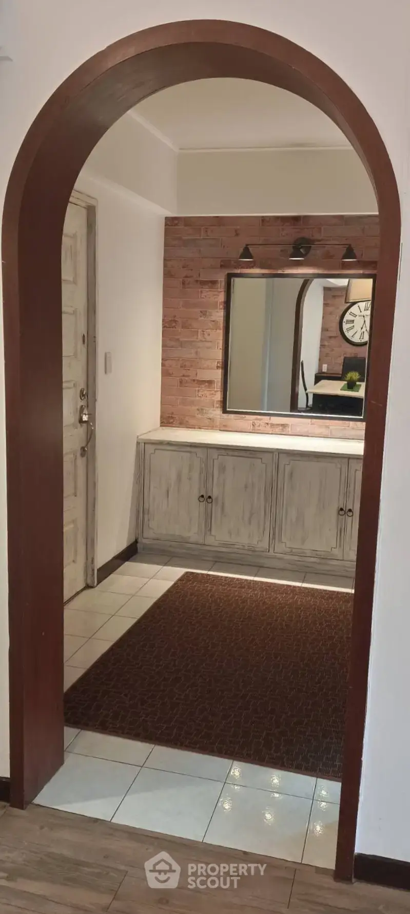 Charming entryway with rustic arch and stylish console table, perfect for welcoming guests.