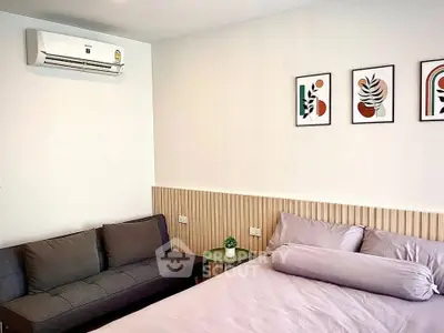 Modern bedroom with stylish decor and air conditioning, featuring a cozy bed and a sleek sofa.