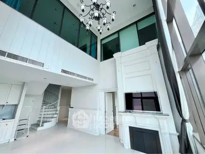 Luxurious high-ceiling living room with elegant chandelier and modern fireplace