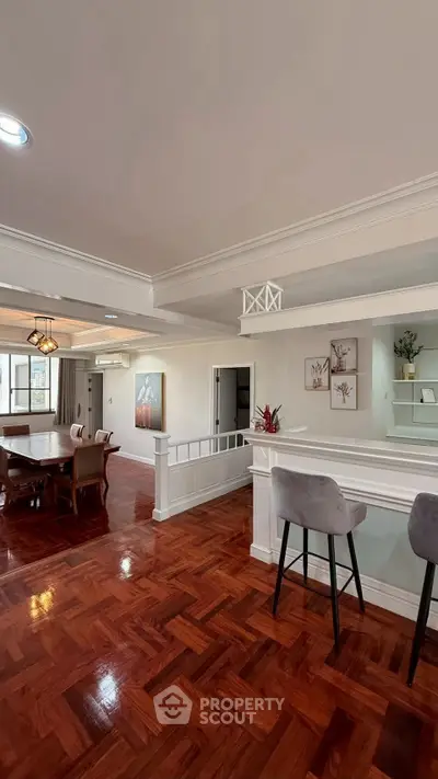 Spacious open-plan living and dining area with elegant wooden flooring and modern decor.