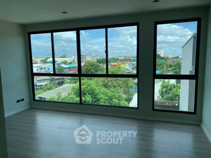 Spacious room with large windows offering a stunning city view, perfect for natural light lovers.