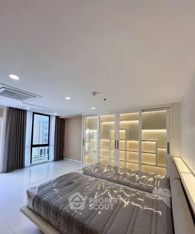 Luxurious bedroom with modern lighting and large windows in a high-rise apartment.