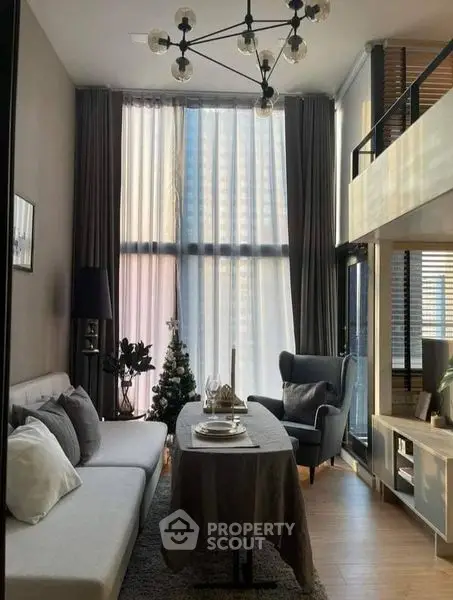 Elegant two-level living space with high ceilings, modern furniture, and abundant natural light filtering through sheer curtains, perfect for urban living.