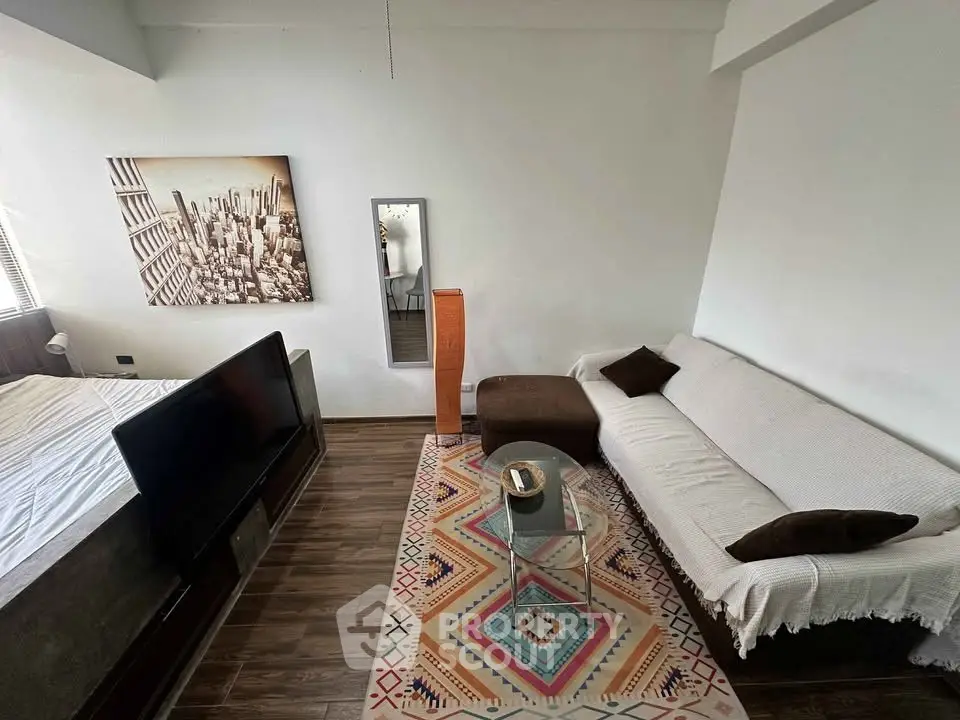 Modern living room with stylish decor and cozy seating area, featuring a large wall art and sleek flooring.