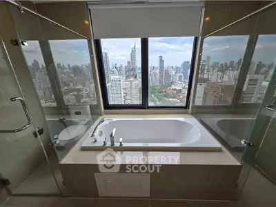 Luxurious bathroom with stunning city skyline view and modern bathtub.