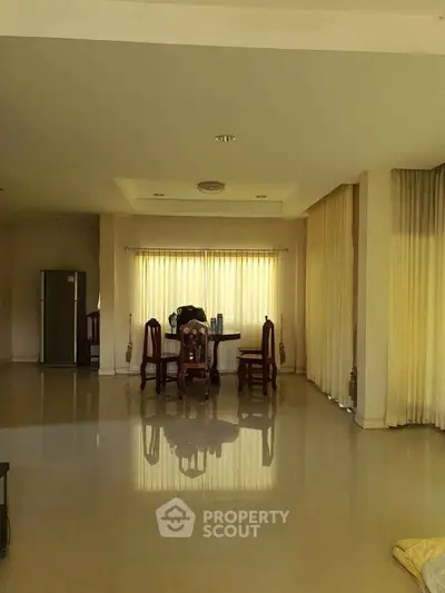 Spacious living room with elegant dining area and large windows for natural light.